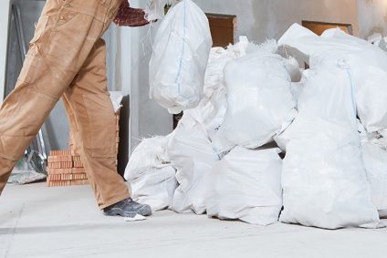 Fachkraft in Schutzkleidung bei der Entfernung von KMF